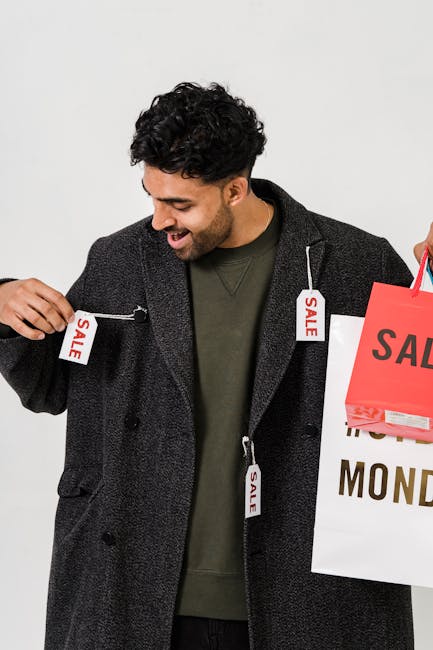 Happy man holding shopping bags with sale tags, signaling retail discounts.